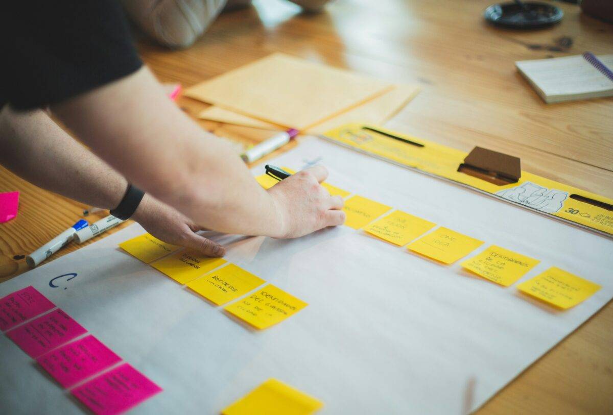 A working professional writing down ideas for a project on post-it notes