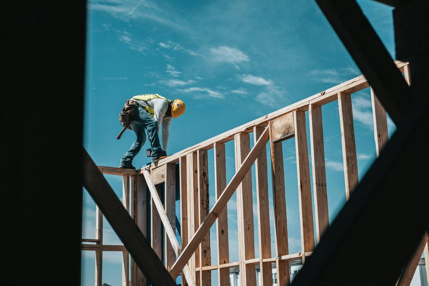 A construction worker putting together the frame for a building