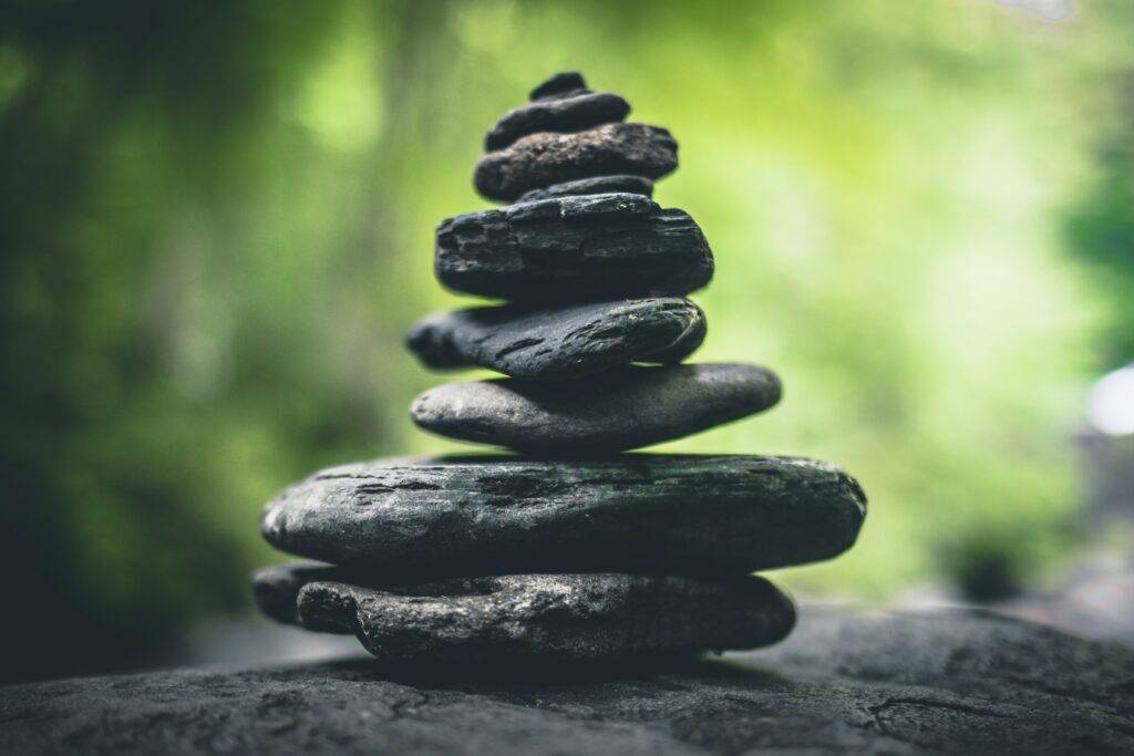 A stack of balanced stones against a blurred green background, evoking calm and mindfulness